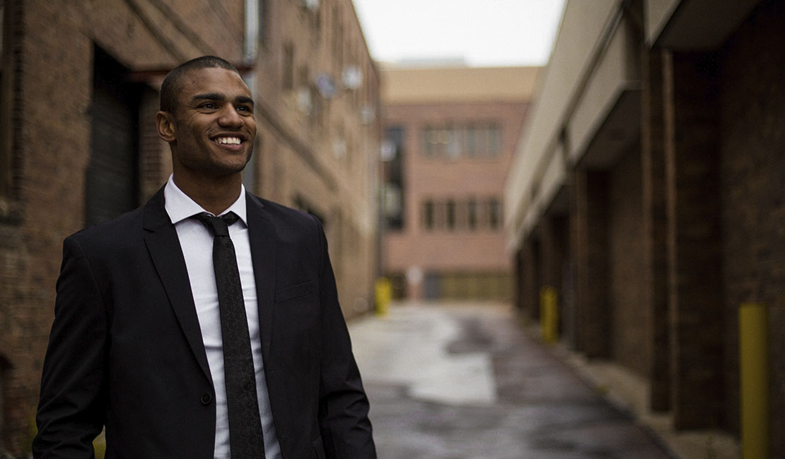 man in suit smiling outdoors in city