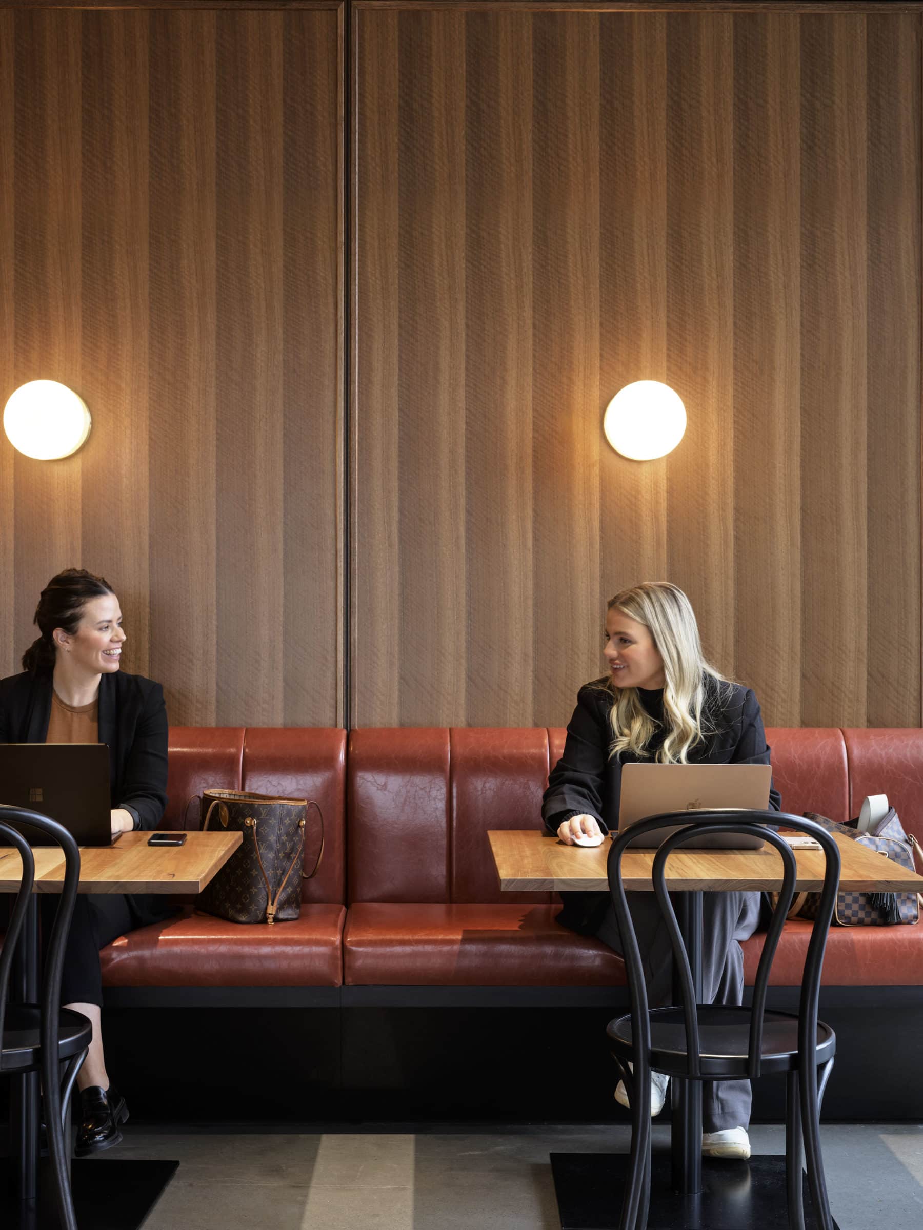 two women sitting in a cafe space chatting