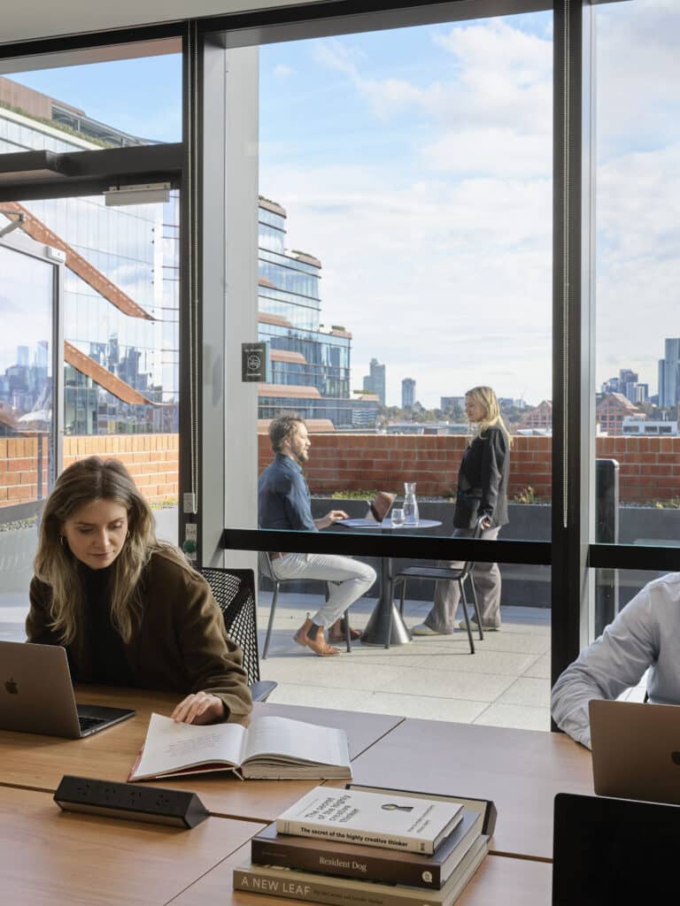 people in an office working with a balcony