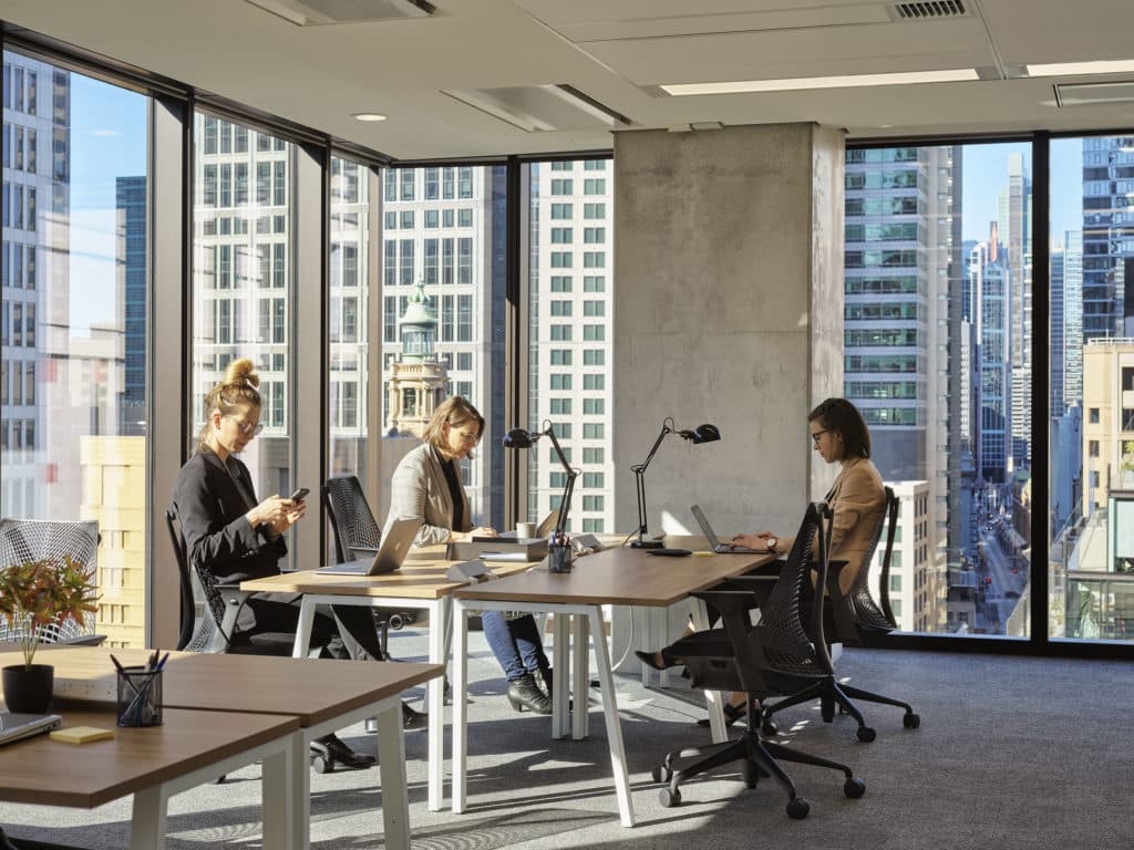 office full of people with city views in the background