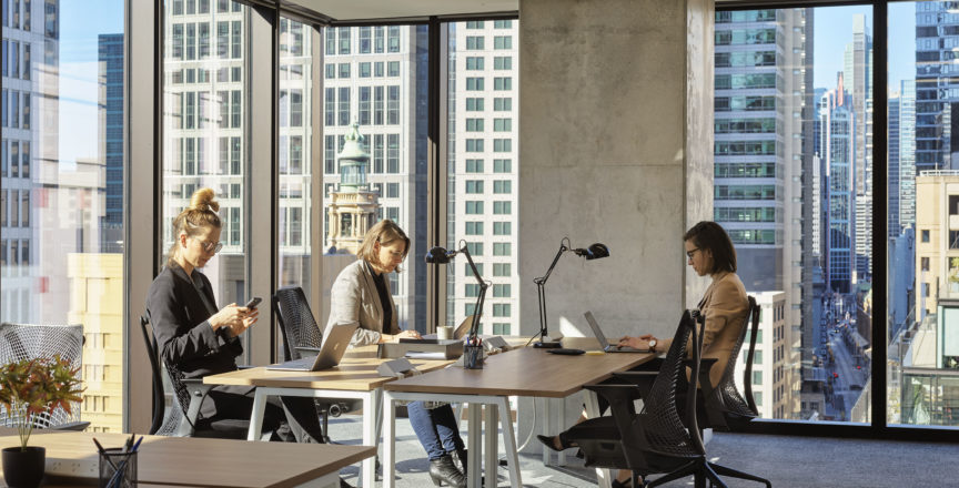 office full of people with city views in the background