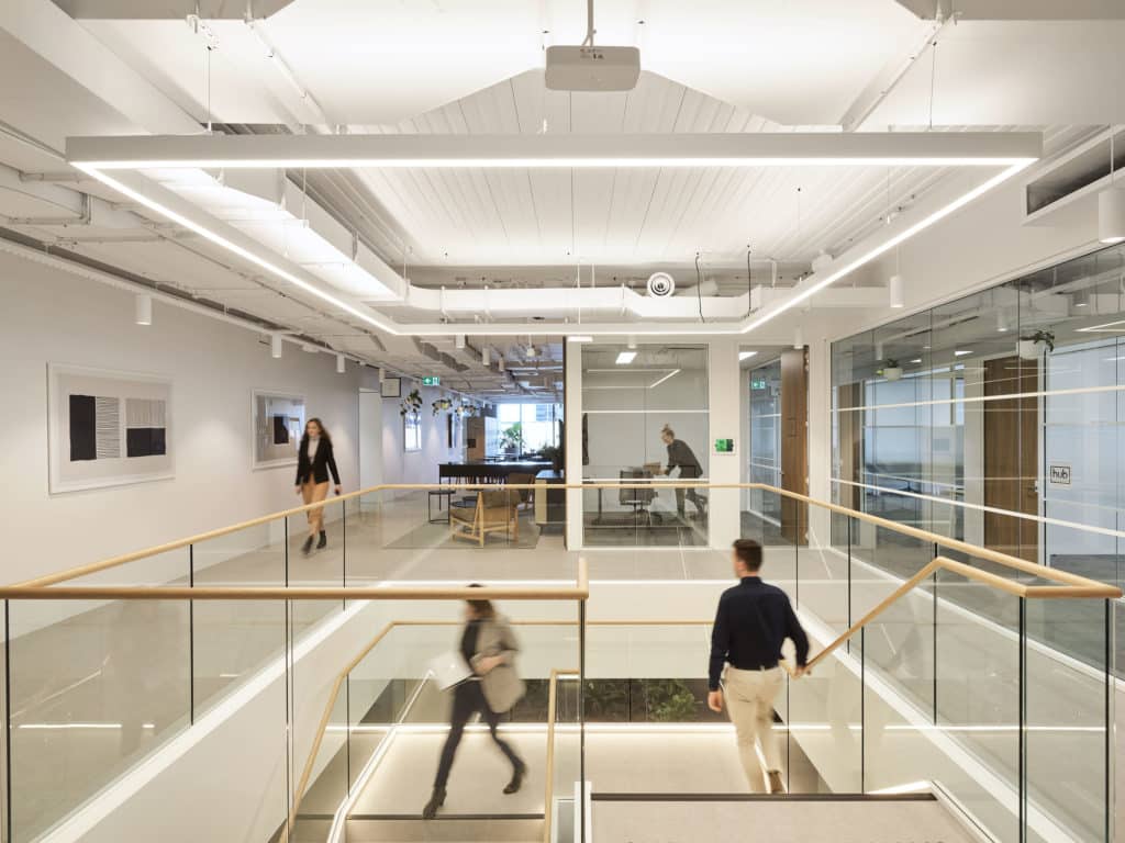 people in an office walking downstairs