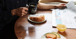 Member events, member holding Hub mug and eating croissant