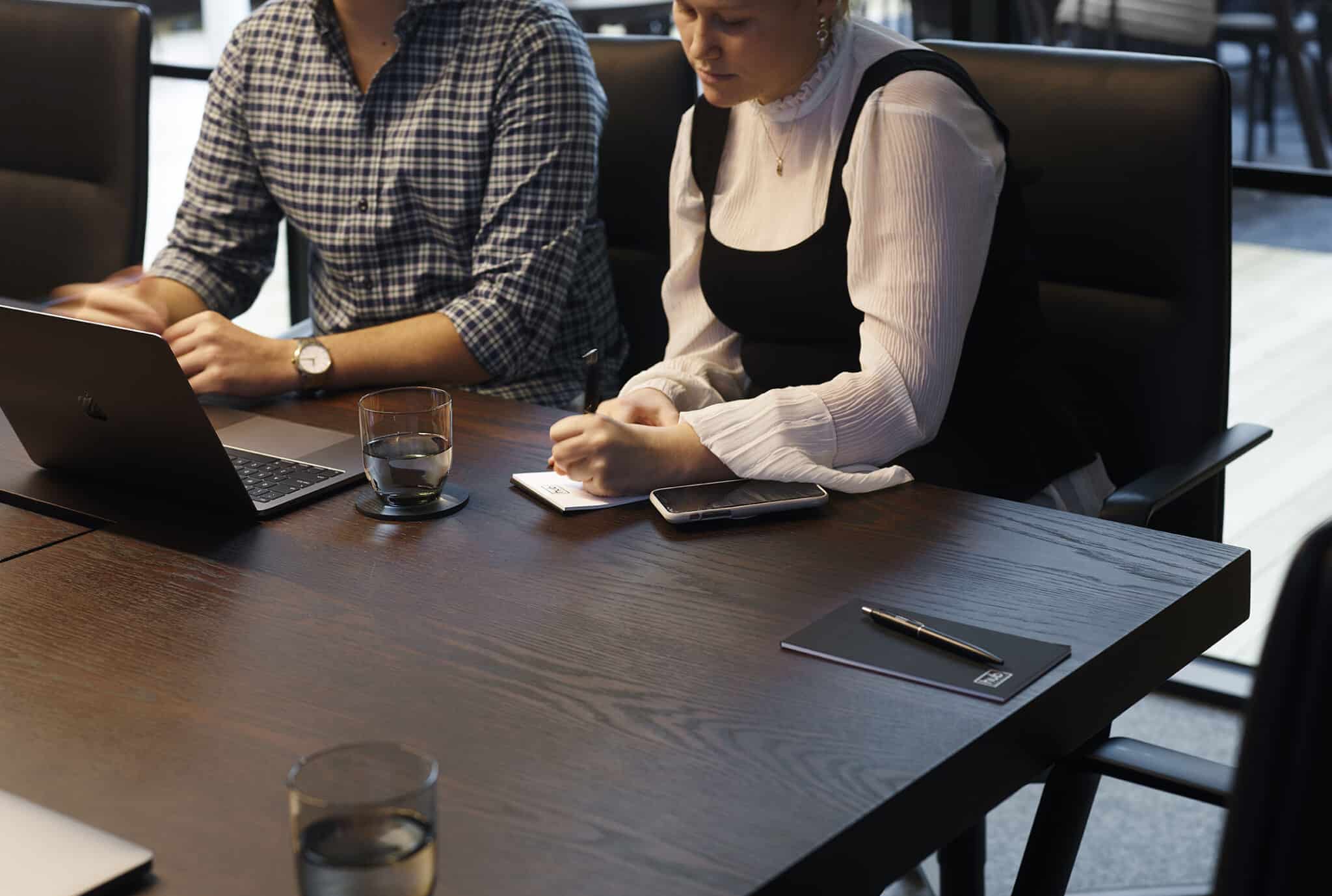 people in meeting writing notes