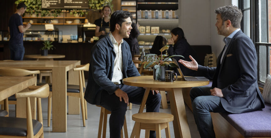 two men speaking in a cafe