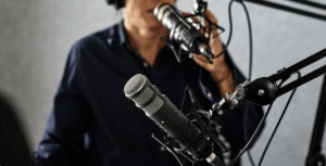 man speaking in to a podcast microphone