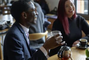 man laughing and holding coffee