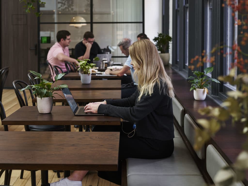 Woman on laptop in hub collins street