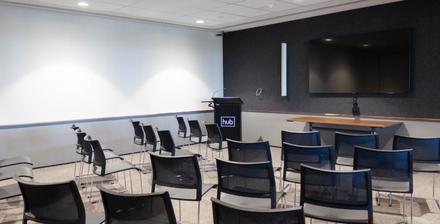 workshop training room with chairs facing a screen and microphone