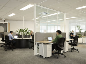 woman and man working at desks in open plan office