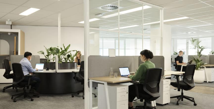 woman and man working at desks in open plan office