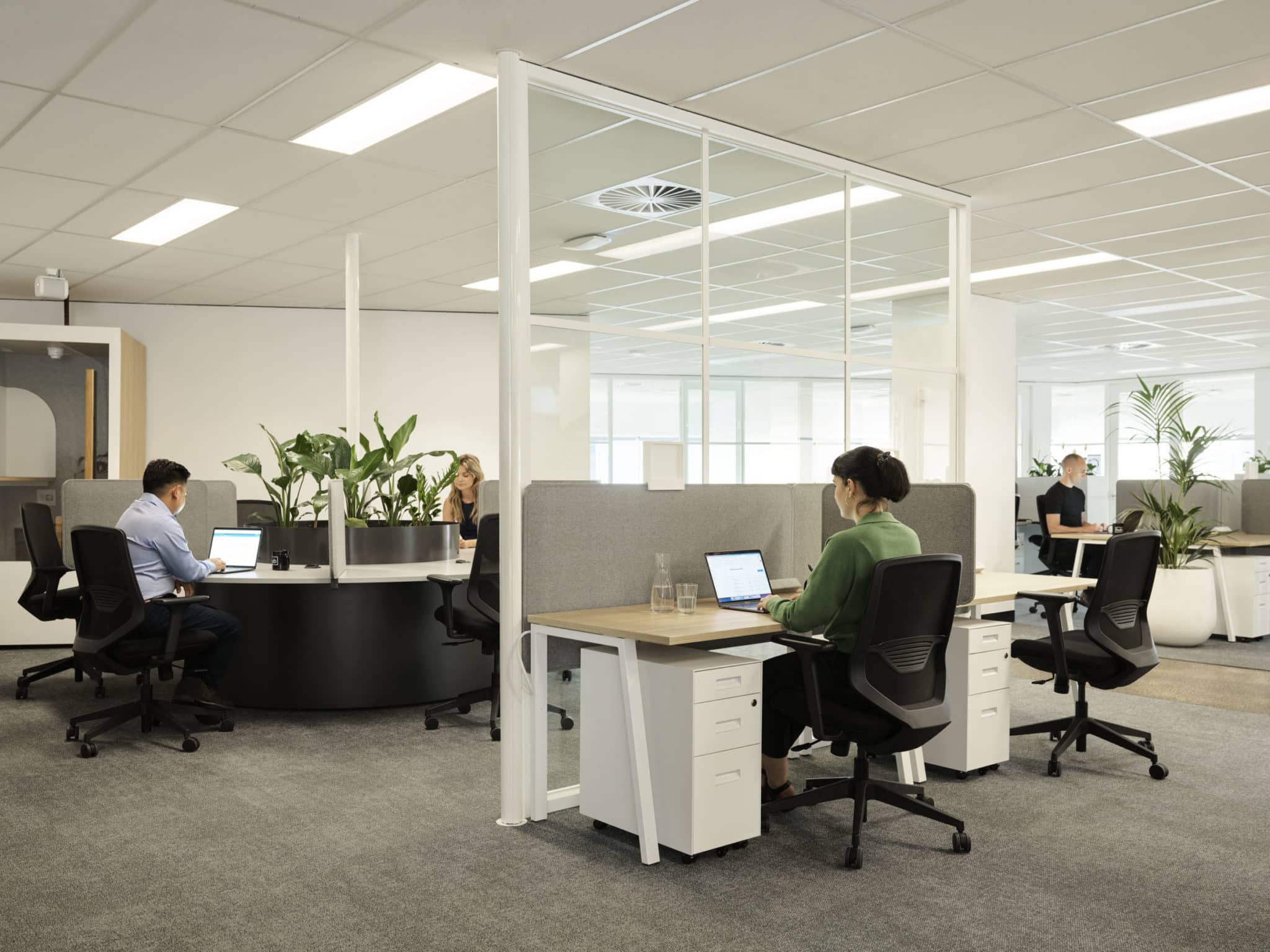 At Hub St Kilda Road woman and man working at desks in open plan office