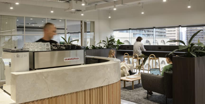 barista making coffee with view of cafe area
