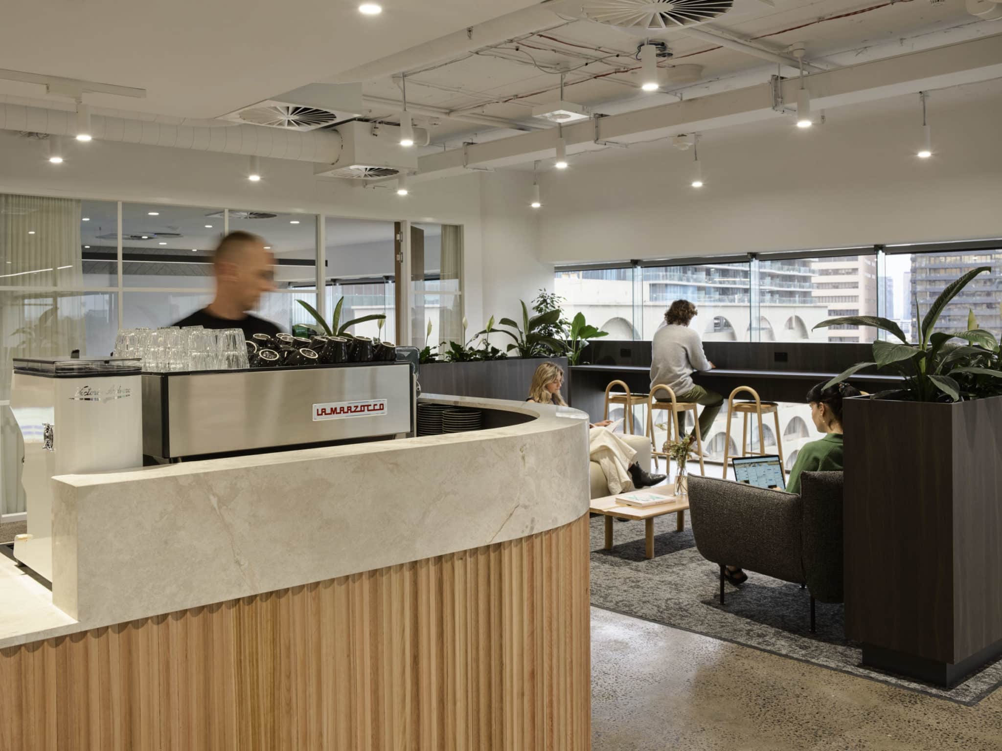 barista making coffee with view of cafe area at Hub St Kilda Road