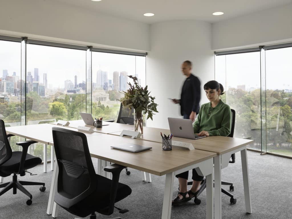 people working in a corner office with a view of Melbourne Skyline at Hub St Kilda Road