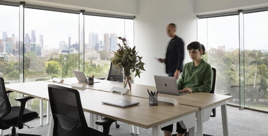 people working in a corner office with a view of Melbourne Skyline