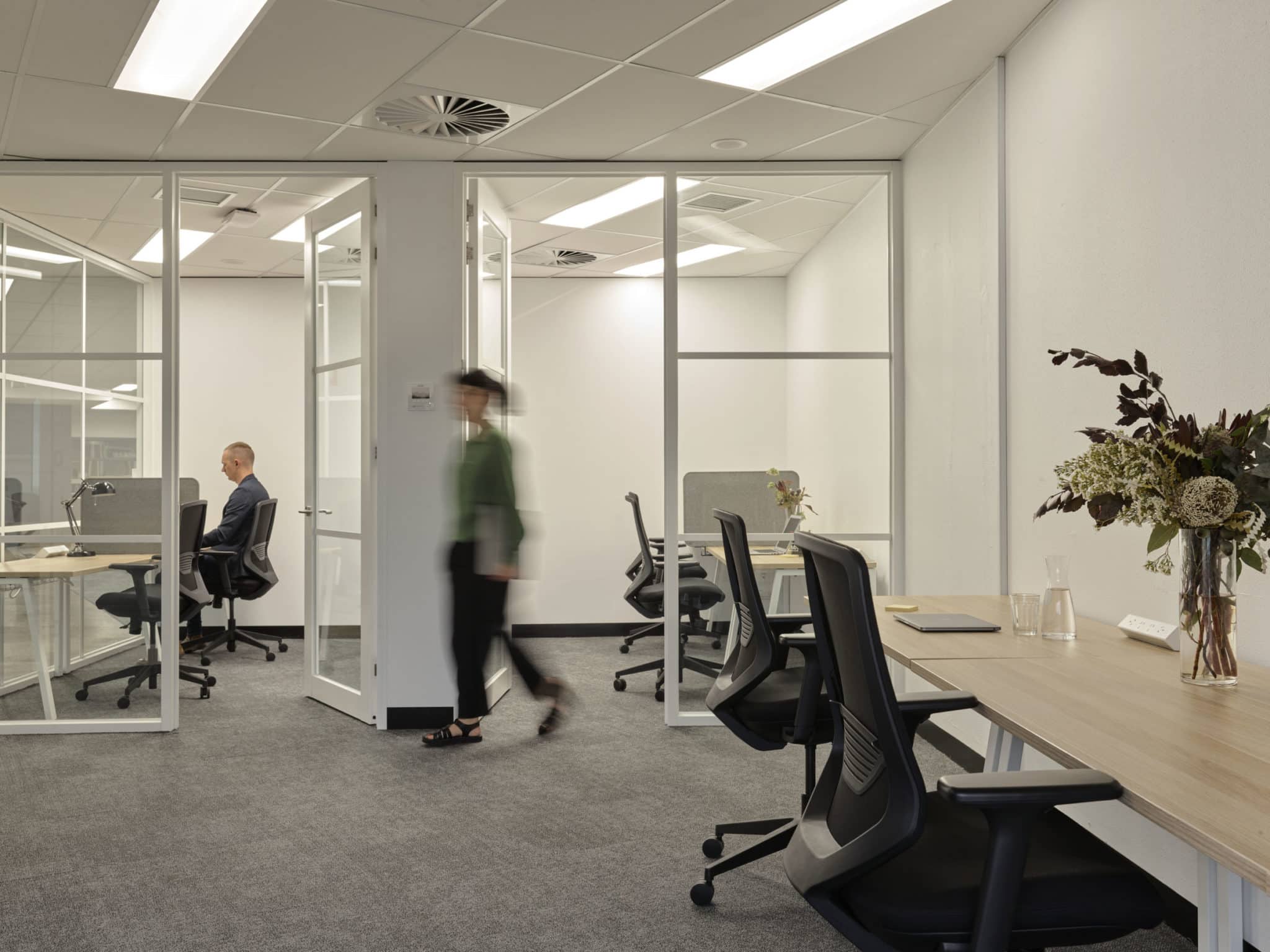 woman walking past an office at Hub St Kilda Road
