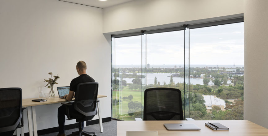 man working alone in office with a view of Albert Park Lake