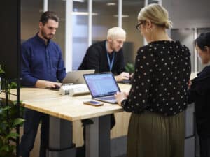 people in an office working at standing desks