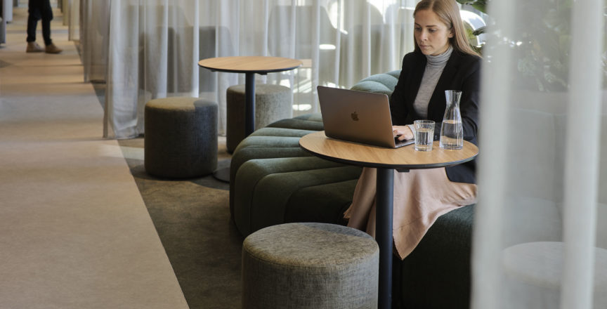 woman working on a laptop in a business lounge