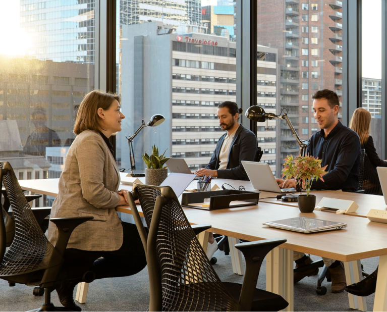 group of people in an office space in Sydney with a view of the city