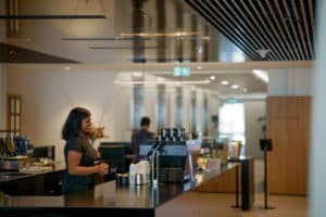 woman smiling at counter serving coffee