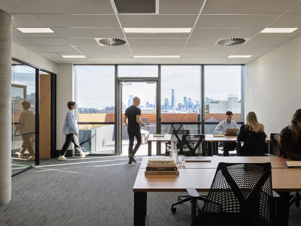 people working in an office with a balcony