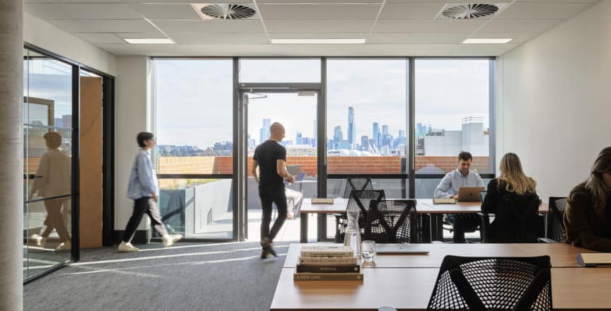 people working in an office with a balcony
