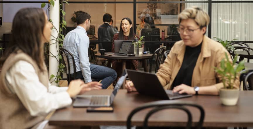 two women in a cafe with laptops