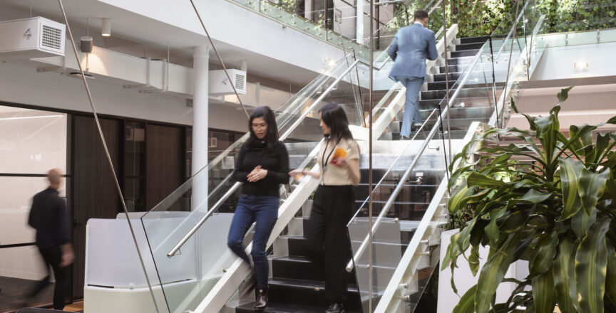two people walking down the stairs in a shared workspace