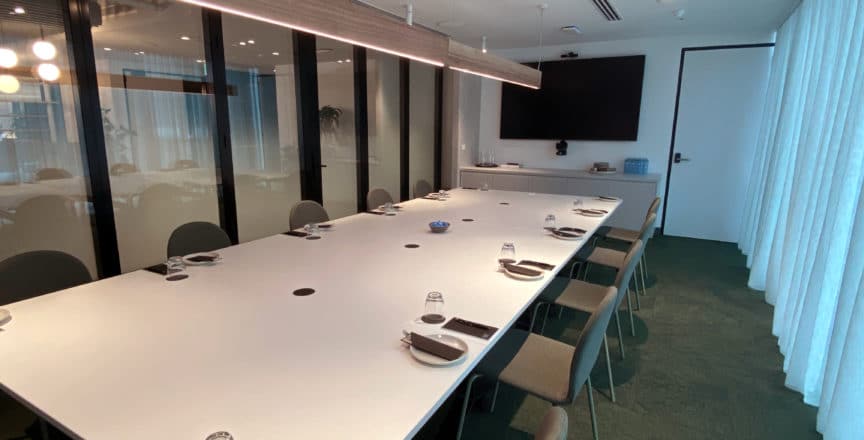 meeting room with a long table, screen, and chairs