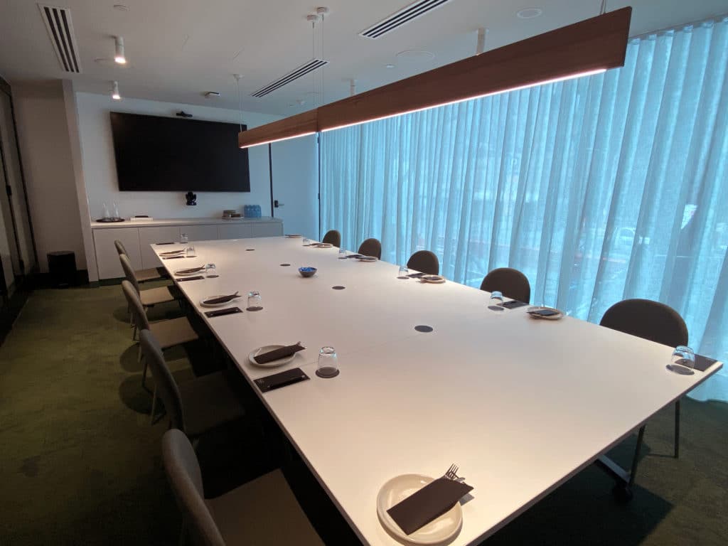 meeting room with a long table, screen, and chairs