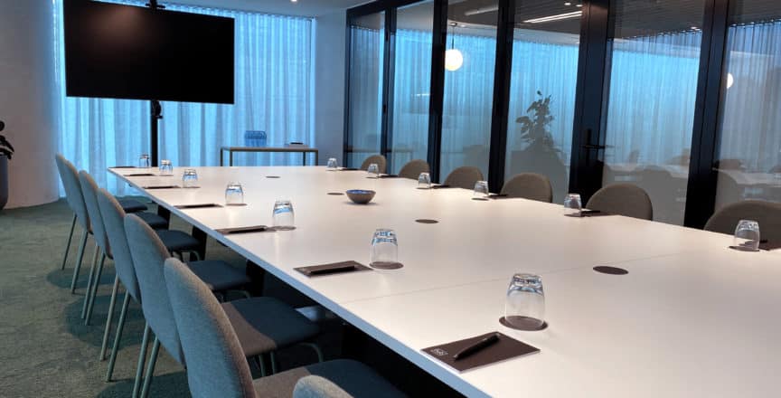 meeting room with a long table, screen, and chairs