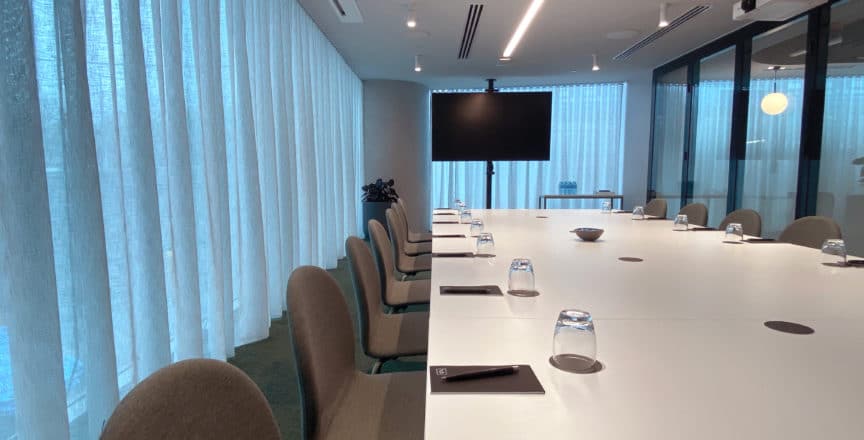 meeting room with a long table, screen, and chairs