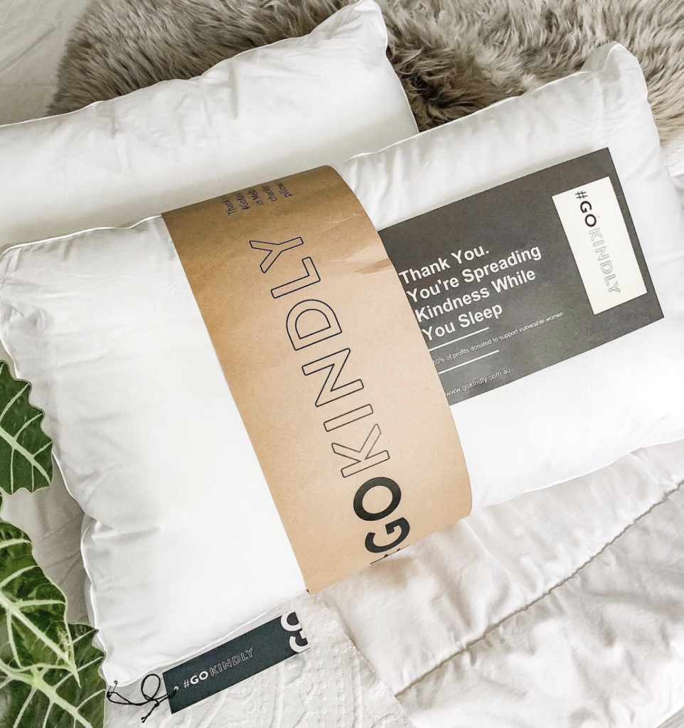 two pillows with a label running across them, saying 'go kindly'