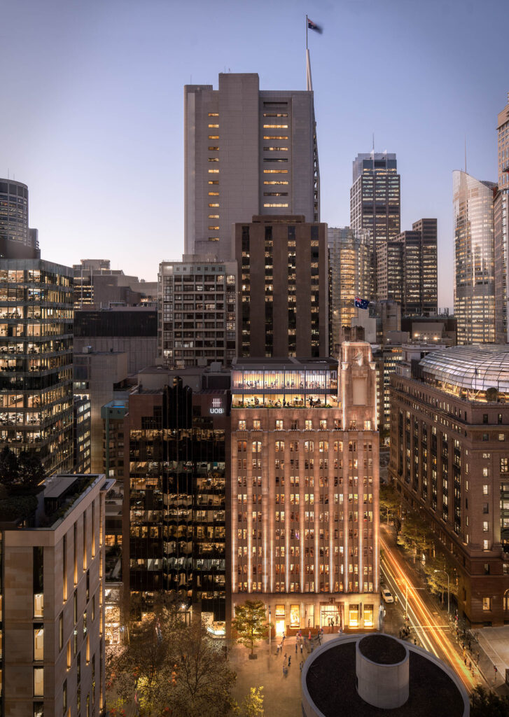 A night time shot of the exterior building of Hub Martin place, featuring lit up windows.