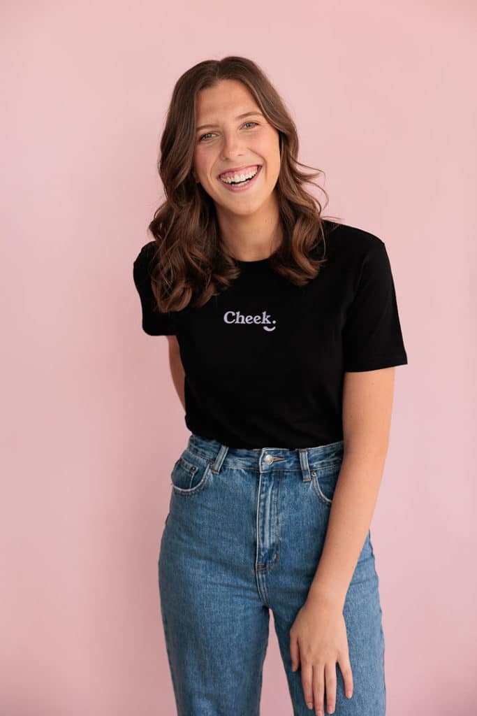 woman standing infront of a pink wall