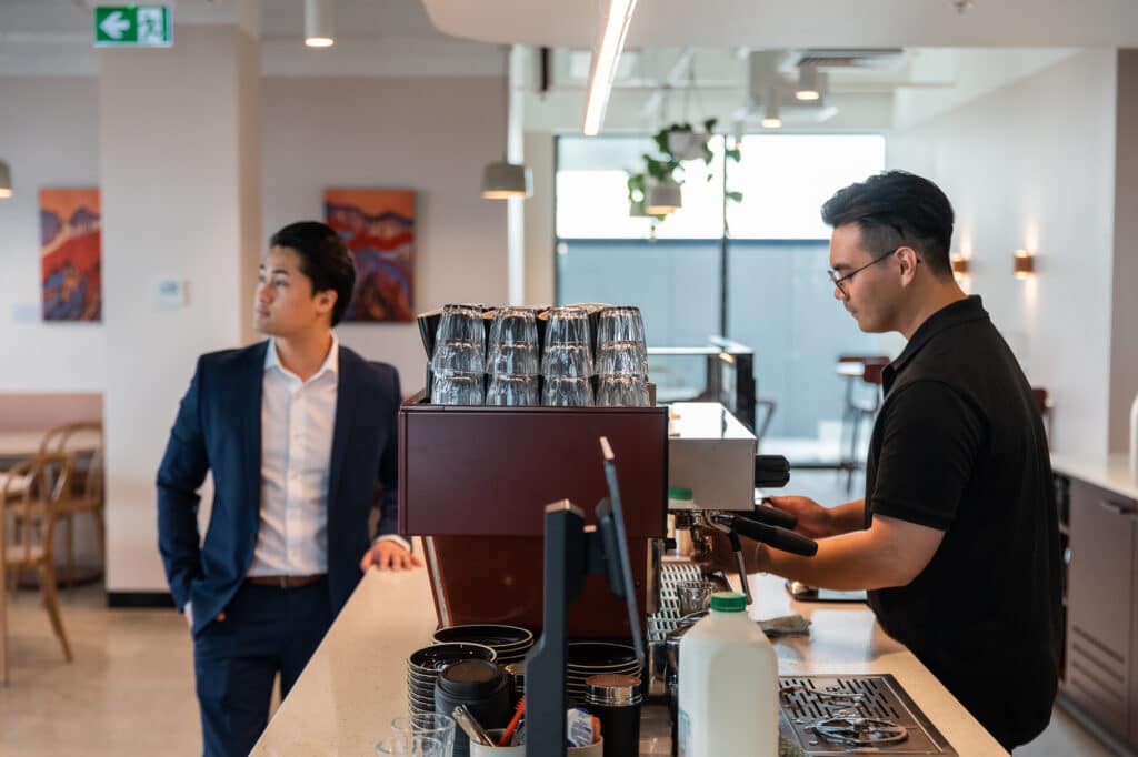 man making coffee in a cafe for customer waiting
