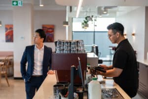 man making coffee in a cafe for customer waiting