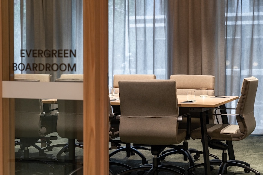 empty boardroom with a large desk and multiple ergonomic chairs