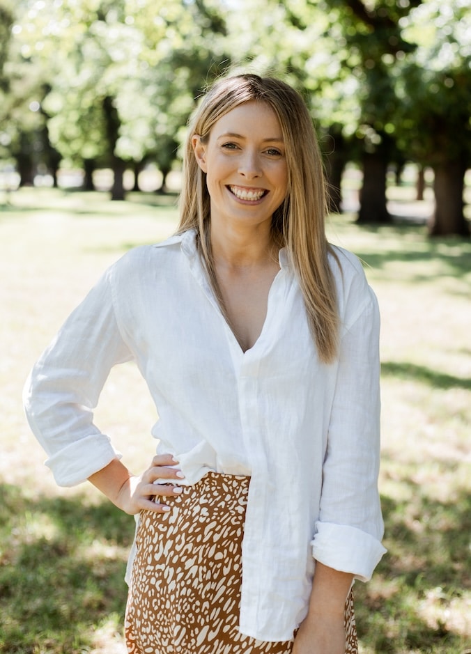 girl in white shirt smiling in a park