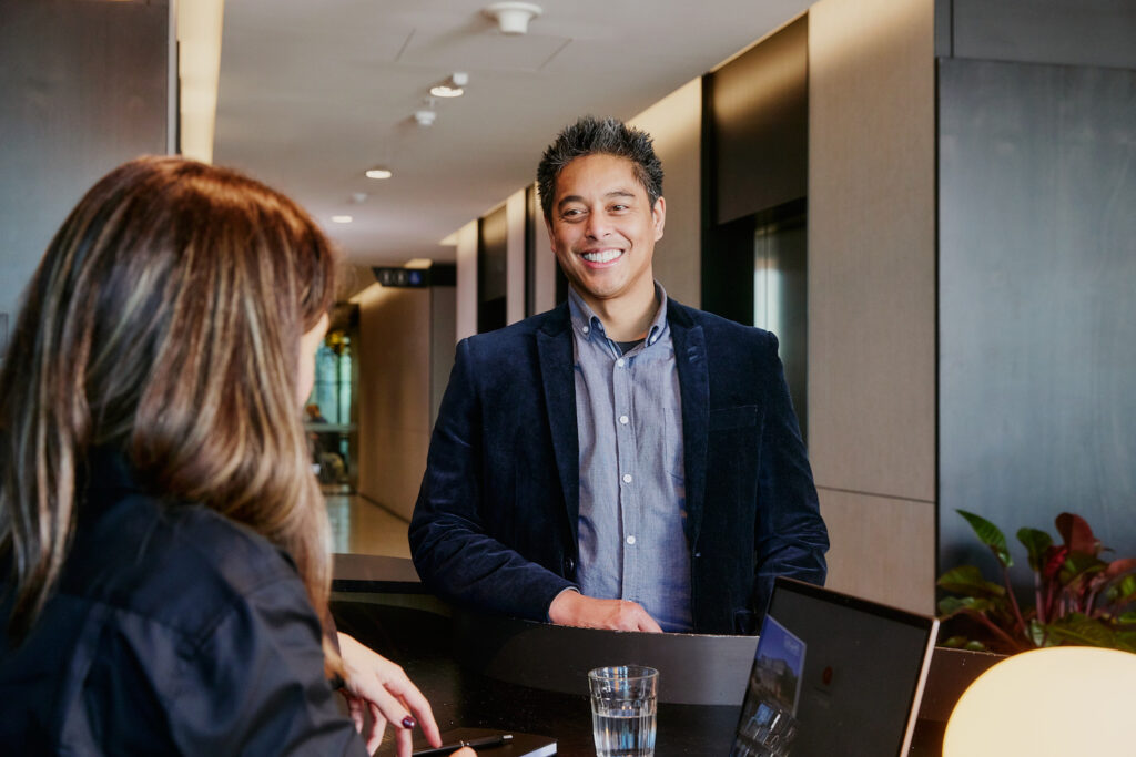 Man at welcome desk smiling at concierge