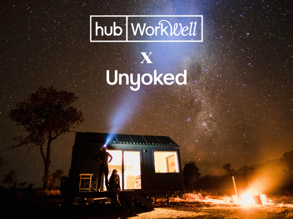 cabin at night with stars in the sky and a bright fire burning in the campfire. workwell hub logo across with the unyoked logo