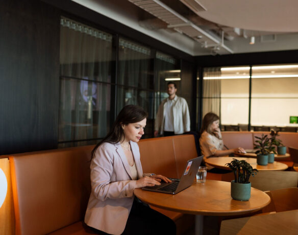 Woman sitting in business lounge working on laptop